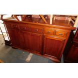 A reproduction cherry wood sideboard, with six drawers over three cupboard doors, 106cm high,