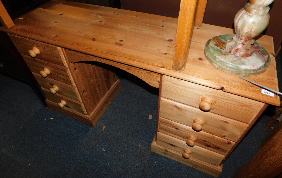 A waxed pine desk or dressing table of eight drawers, 77cm high, 130cm wide, 43cm deep.