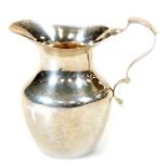 An Edwardian silver cream jug, with ear handle, silver gilt interior and shouldered body, Birmingham