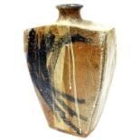 A naively decorated pottery vessel, of shouldered form with compressed stem, splash decorated in bla
