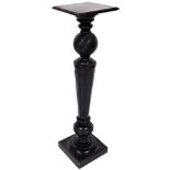 An early 20thC ebonised plant stand, with square top on an orb and tapering reeded stem, with compre