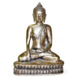 An Eastern base metal figure of a God, in crossed leg position, on a shaped part gadrooned base with