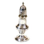 A George III silver caster, with pierced domed lid, urn finial, bellied circular body decorated with