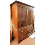 An early 19thC mahogany linen press, with moulded cornice raised above two doors revealing a plain i