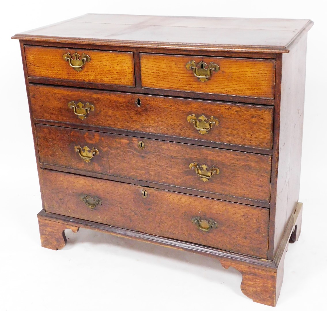 An 18thC oak chest, of two short and three long graduated cock beaded drawers, each with swan neck p