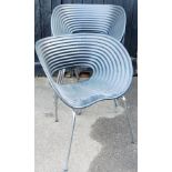 A set of four plastic patio style chairs, each of shaped oval form, with piercings to the centre, on