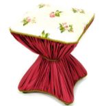 An early 20thC Diabolo stool of hourglass form, all over upholstered in floral material, 50cm high,