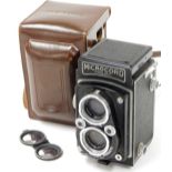 A 20thC Microcord box camera, in black textured pattern, 15cm high, with leather case.