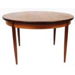 A vintage G Plan extending dining table, of circular form on turned tapering legs, (when closed) 70c