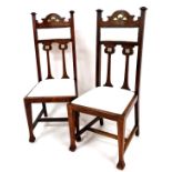 A pair of late 19thC Art Nouveau oak chairs, with arched top rails, compressed square finials and ov