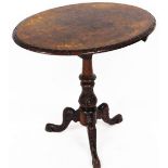 A late Victorian walnut tilt top occasional table, the oval quarter veneered top with a heavily carv