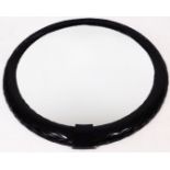 A large American ebonised mirror, of circular form, with a moulded rope twist outline and plain glas