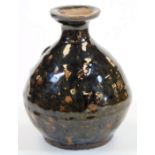 A West Country type glazed pottery bottle, of globular form, with a fixed seal to the neck, slip gla