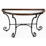 A 20thC D-end console table, with glazed top in a moulded framework on a wrought iron scroll stand,