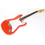 A Squier Fender Bullet six string electric guitar, in red and white colourway, 101cm wide, in associ