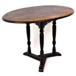 An early 20thC oak occasional table, the oval top raised on turned reeded legs, joined by a tricorn