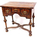 A late 18thC walnut lowboy, the rounded top raised above three frieze drawers, on turned legs, termi