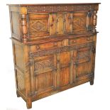 A Jacobean style oak court cupboard, of rectangular form, the upper section with a carved cornice on