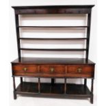 An 18thC oak dresser, the top with a fixed moulded cornice, raised above three Delft racks, the subs