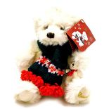 A Harrods plush jointed teddy bear, in white, wearing scarf with label to the ear, 26cm high.
