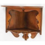 An early 20thC mahogany hanging corner shelf, with semi circular top, above shaped under section, wi