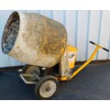 A cement mixer, on a wheeled base, in yellow.
