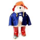A mid 20thC Paddington Bear plush jointed teddy bear, in blue duffle coat with red hat and red Dunlo