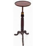 An early 20thC mahogany plant stand, the circular top raised on a reeded stem, terminating in heavil