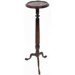 A late 19th/early 20thC mahogany plant stand, the circular moulded top raised on a reeded stem, term