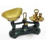 A 20thC Ibrasco table top scale, with brass pans and weights, the base in green, 24cm, high.