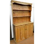 A 20thC pine open dresser, with fixed cornice, raised above two shelves and double cupboard beneath,