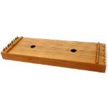 An oak zither, of rectangular form with two central holes, with twelve strings, 58cm wide.