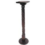 A late 19thC ebonised plant stand, the oak top on a heavily carved turned stem and circular foot, 13
