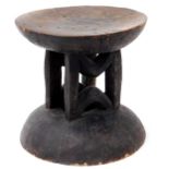 A 19thC African tribal stand or headrest, with circular dish top on a vertical stem and domed foot,