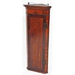 A late 19thC mahogany hanging corner cupboard, of slender form, the door with a wide crossbanding re