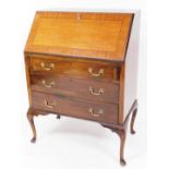 A 20thC mahogany bureau, the fall held by loafers, with a wide cross banding, revealing a drawer and