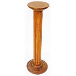 A 19thC oak wig stand, the circular top raised on a fluted stem and stepped circular base, 76cm high