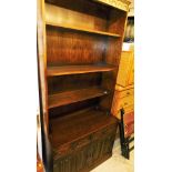 A 20thC oak linen fold open bookcase, 203cm high, above two drawers and double cupboard on a block b