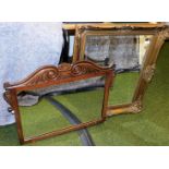 A heavily carved oak framed mirror, with scroll top and a further hanging mirror with bevelled glass