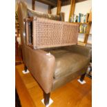 A large deep seated leatherette finish wing armchair, on square front and saber back legs, and a rus