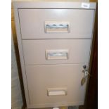 A three drawer filing cabinet with key.
