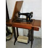 A freestanding oak cased treadle sewing machine, on iron stand, 79cm high, 89cm wide, 40cm deep.