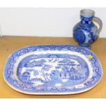 An early 20thC blue and white Willow pattern meat platter and a Ypres style stoneware flagon. (2)