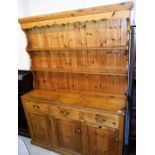 A pine kitchen dresser, with fixed cornice raised above two Delft racks, with three frieze drawers a