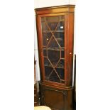 A George III style mahogany freestanding corner display cabinet, with fixed cornice raised above ast