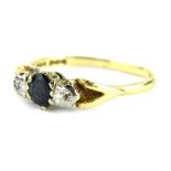 An 18ct gold sapphire and diamond dress ring, with oval cut sapphire flanked by two illusion set