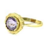 A 9ct gold amethyst dress ring, the circular stone in a rub over setting with pleated gold sides