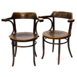 A pair of early 20thC bentwood armchairs in the manner of Thonet, each with a shaped back, a pressed