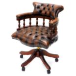 A mahogany and brown buttoned leather swivel office chair, on plastic castors. The upholstery in