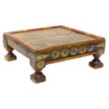 An African tribal low table or stand, decorated with a band part in red with a planked top,